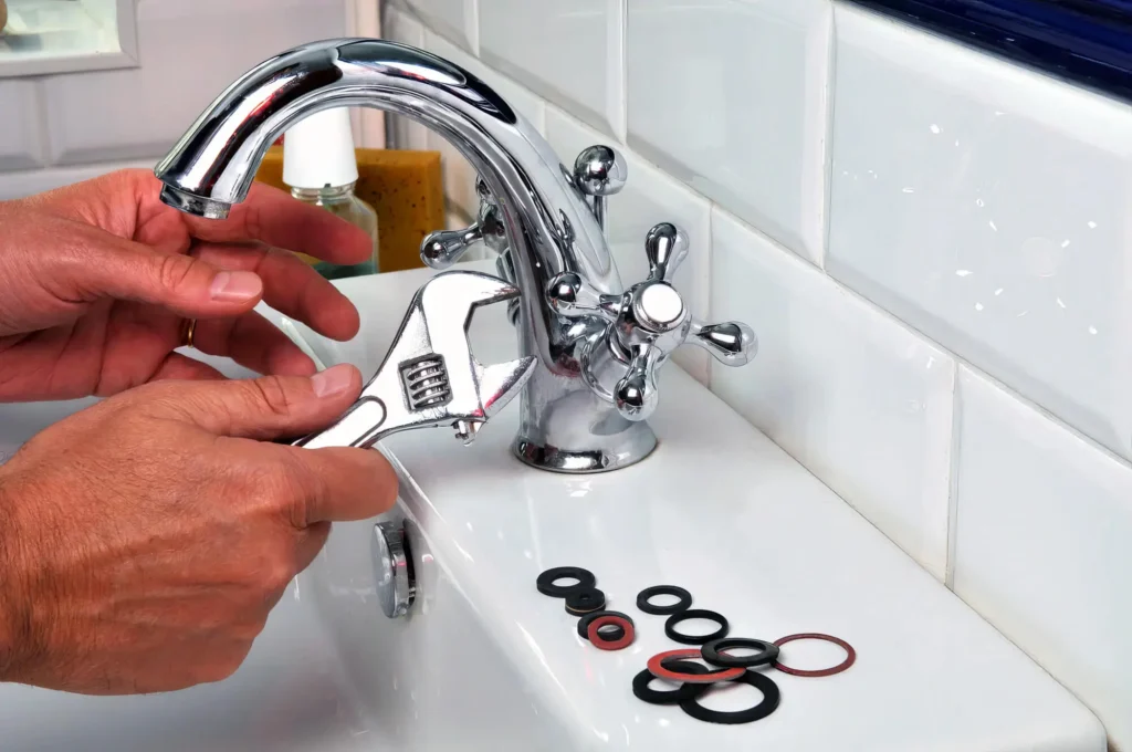 Plumber performing maintenance on a bathroom faucet in Holladay