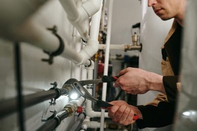 Plumbers maintaining commercial plumbing pipes in Holladay
